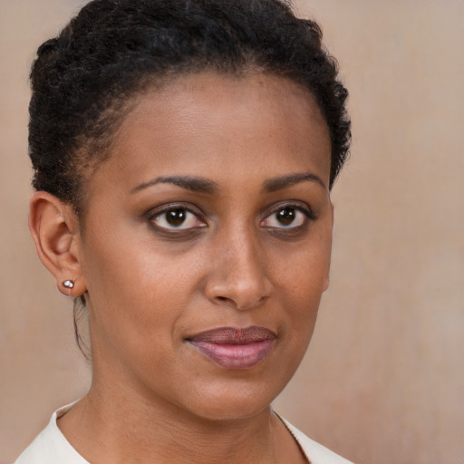 Joyful black young-adult female with short  brown hair and brown eyes