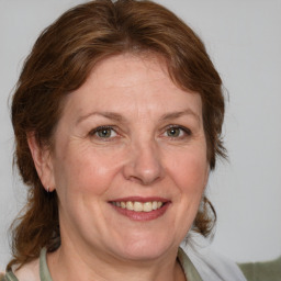 Joyful white adult female with medium  brown hair and green eyes