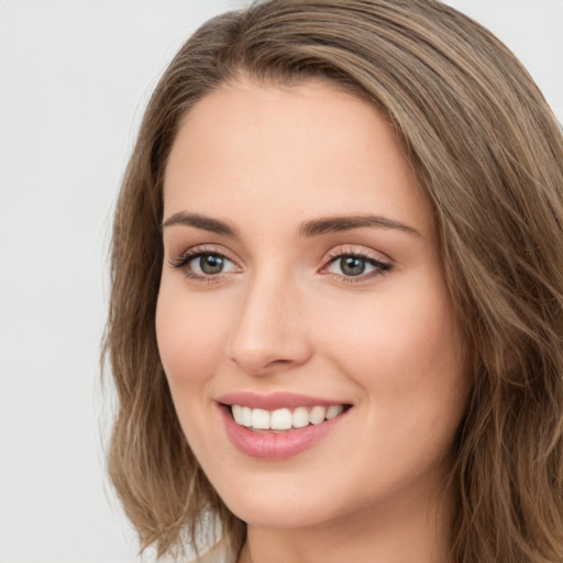 Joyful white young-adult female with long  brown hair and green eyes