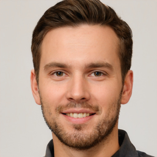 Joyful white young-adult male with short  brown hair and grey eyes