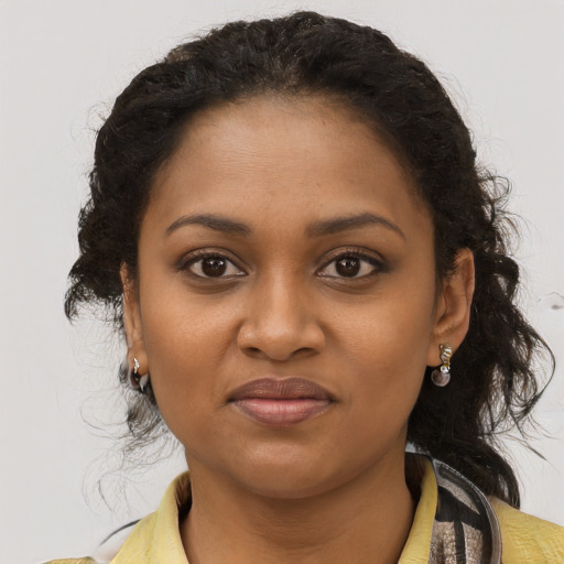 Joyful black young-adult female with medium  brown hair and brown eyes