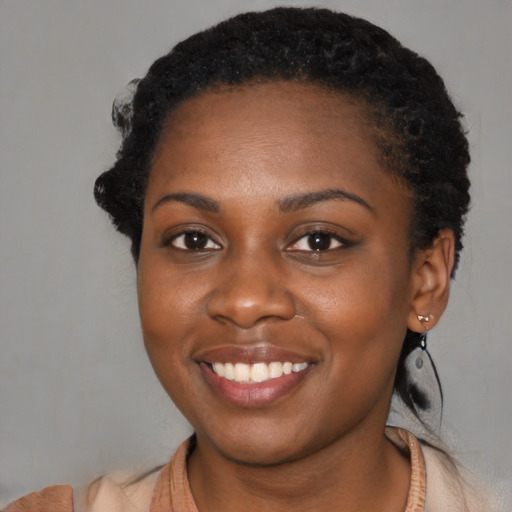Joyful black young-adult female with medium  brown hair and brown eyes