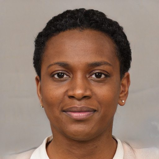 Joyful black young-adult female with short  black hair and brown eyes
