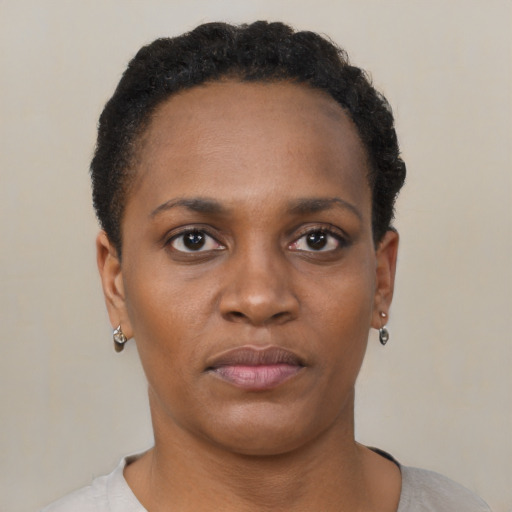 Joyful black young-adult female with short  black hair and brown eyes