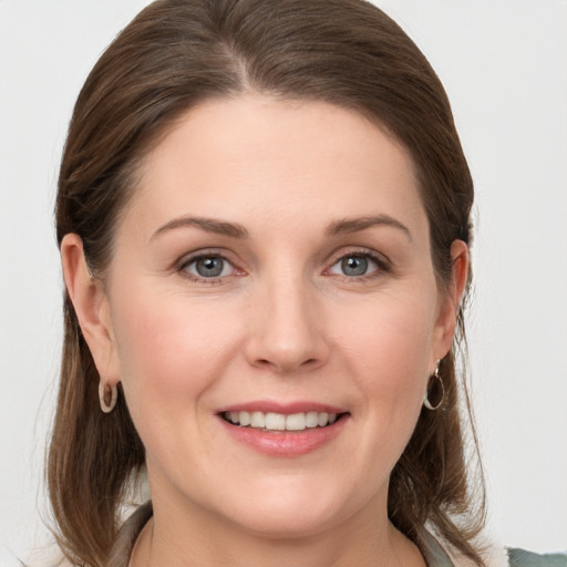 Joyful white young-adult female with medium  brown hair and grey eyes