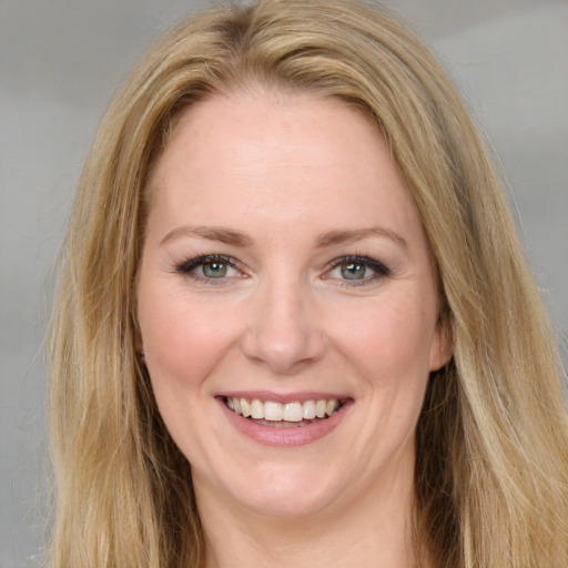 Joyful white young-adult female with long  brown hair and blue eyes