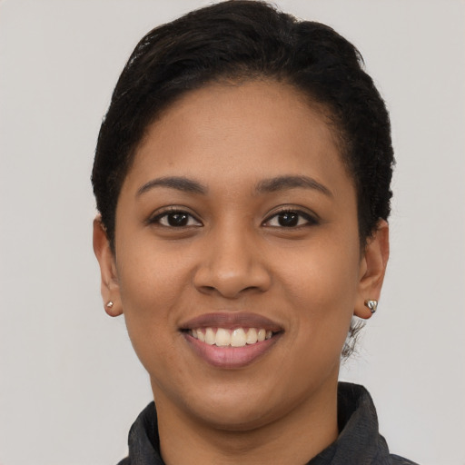 Joyful latino young-adult female with short  black hair and brown eyes