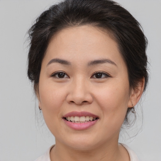 Joyful asian young-adult female with medium  brown hair and brown eyes