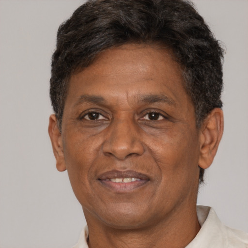 Joyful black adult male with short  brown hair and brown eyes