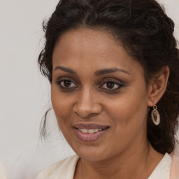 Joyful black young-adult female with long  brown hair and brown eyes