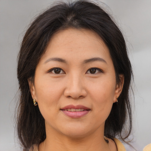 Joyful asian adult female with medium  brown hair and brown eyes