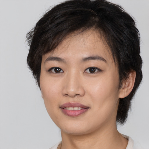 Joyful asian young-adult female with medium  brown hair and brown eyes