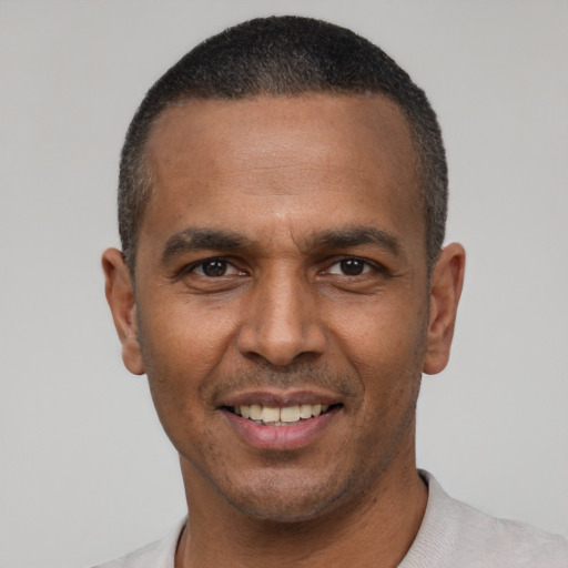 Joyful latino adult male with short  black hair and brown eyes