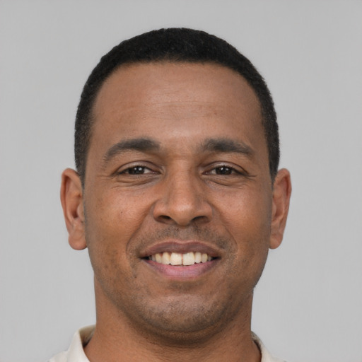 Joyful black young-adult male with short  black hair and brown eyes