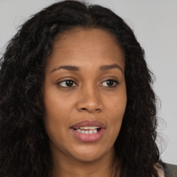 Joyful black young-adult female with long  brown hair and brown eyes