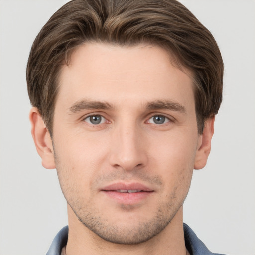 Joyful white young-adult male with short  brown hair and grey eyes