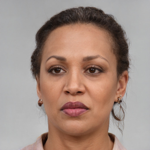 Joyful latino adult female with medium  brown hair and brown eyes