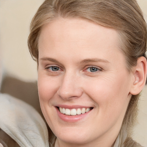 Joyful white young-adult female with medium  brown hair and blue eyes