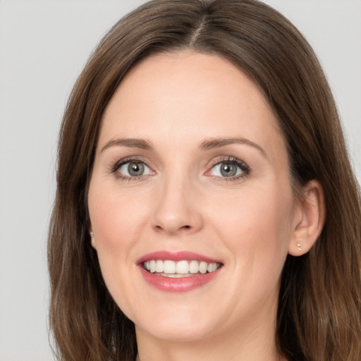 Joyful white young-adult female with long  brown hair and grey eyes