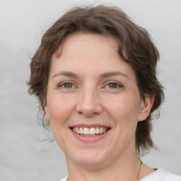 Joyful white adult female with medium  brown hair and green eyes