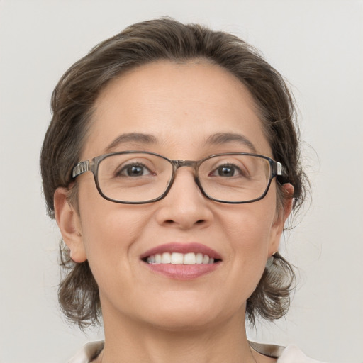 Joyful white adult female with medium  brown hair and grey eyes