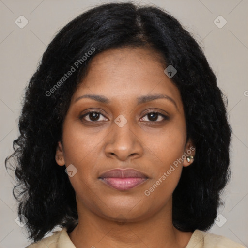 Joyful black young-adult female with long  black hair and brown eyes