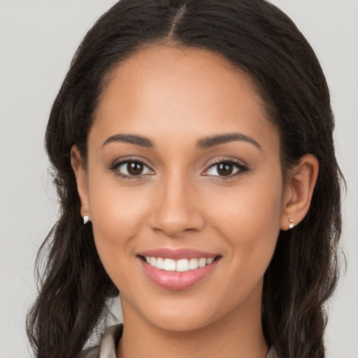 Joyful latino young-adult female with long  brown hair and brown eyes