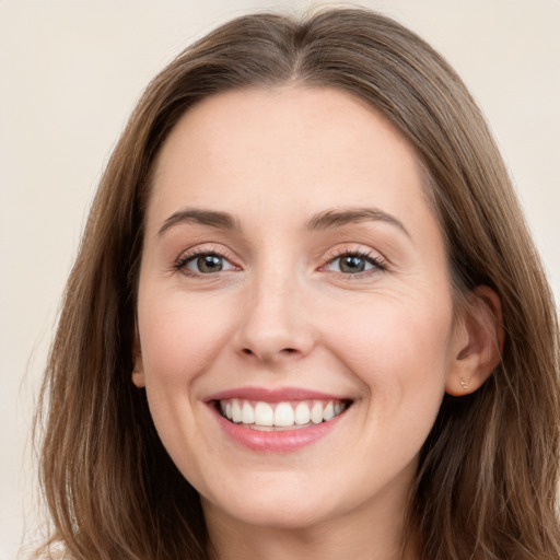 Joyful white young-adult female with long  brown hair and grey eyes