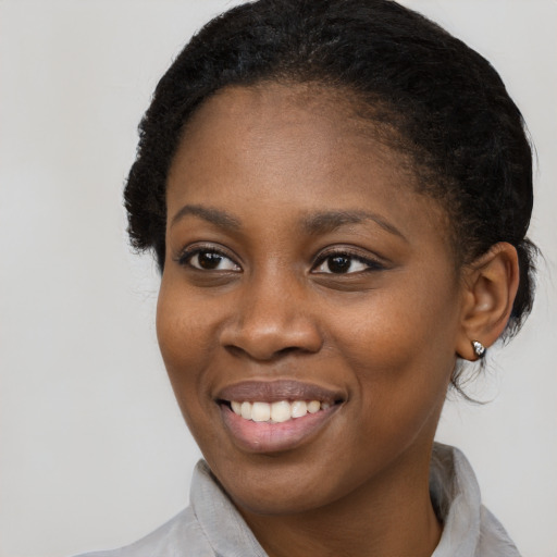 Joyful black young-adult female with long  brown hair and brown eyes