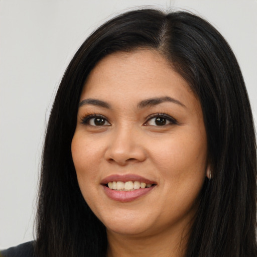 Joyful latino young-adult female with long  brown hair and brown eyes