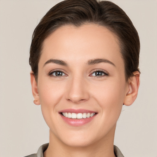 Joyful white young-adult female with short  brown hair and brown eyes