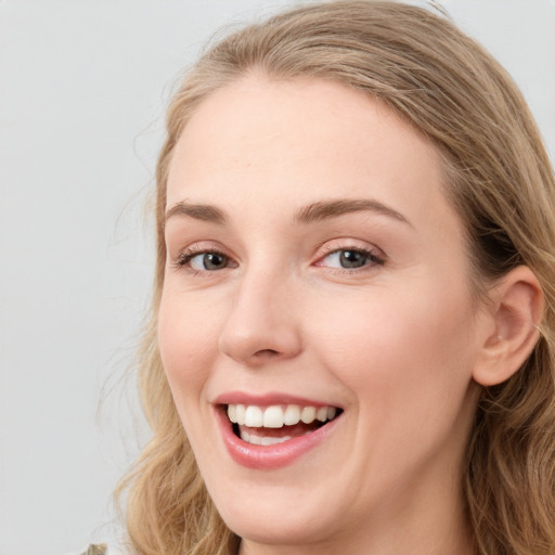 Joyful white young-adult female with long  brown hair and blue eyes