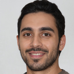 Joyful latino young-adult male with short  black hair and brown eyes