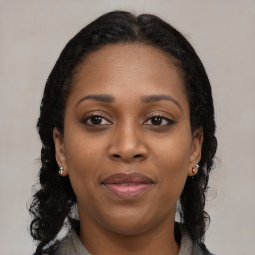 Joyful black young-adult female with long  brown hair and brown eyes