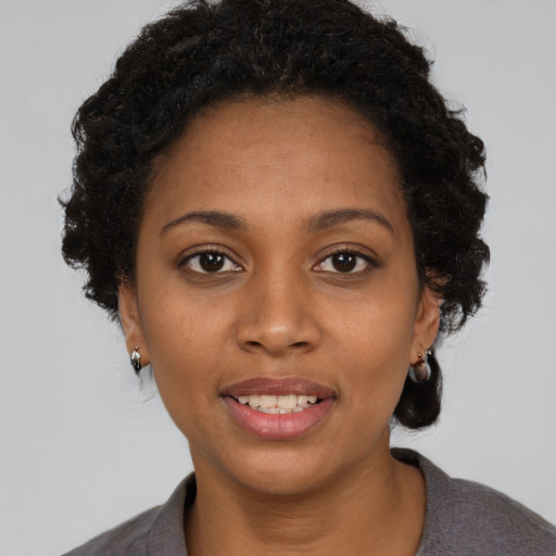 Joyful black young-adult female with short  brown hair and brown eyes