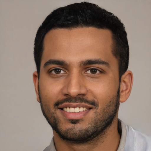 Joyful latino young-adult male with short  black hair and brown eyes