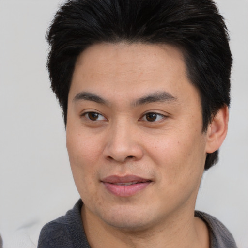 Joyful asian young-adult male with short  brown hair and brown eyes