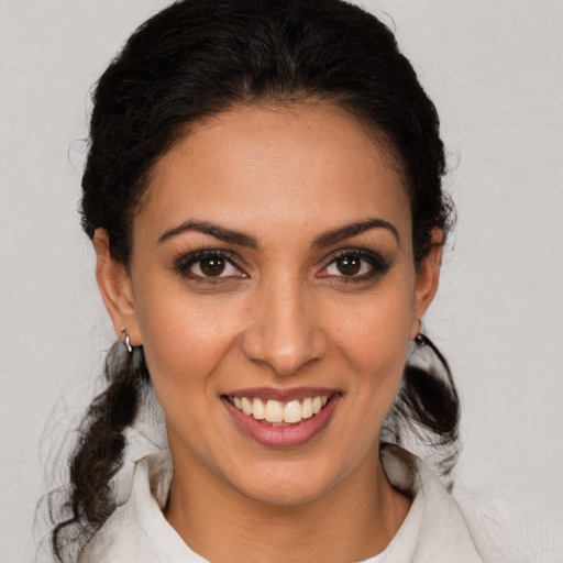 Joyful latino young-adult female with medium  brown hair and brown eyes