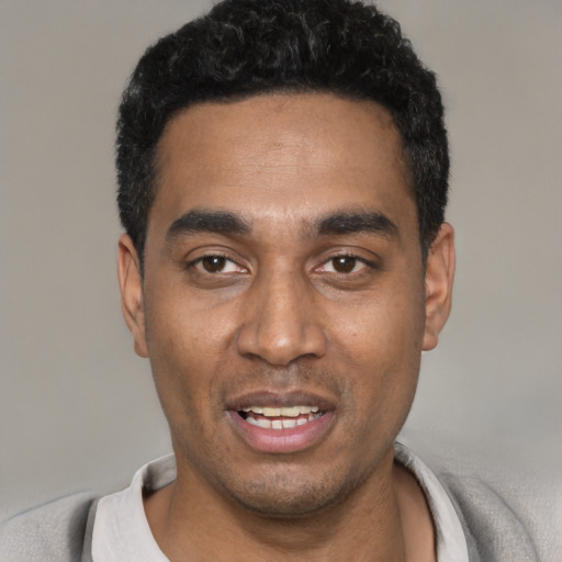 Joyful black young-adult male with short  black hair and brown eyes