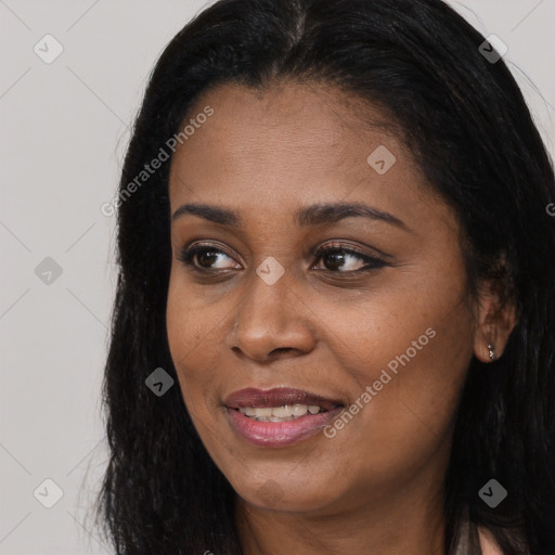 Joyful black young-adult female with long  black hair and brown eyes