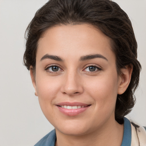 Joyful white young-adult female with medium  brown hair and grey eyes