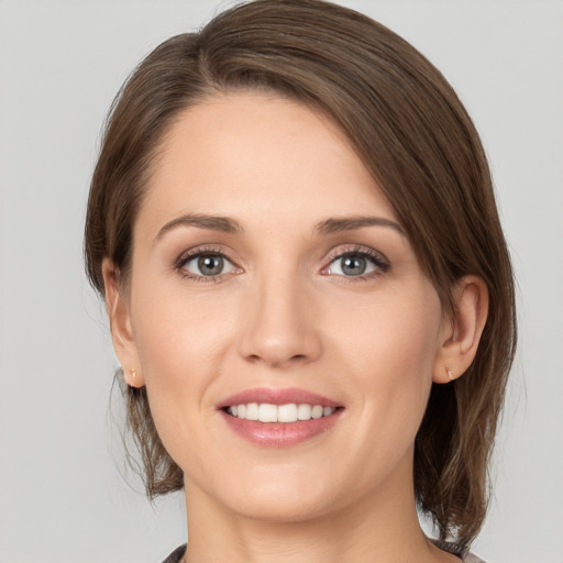 Joyful white young-adult female with medium  brown hair and grey eyes