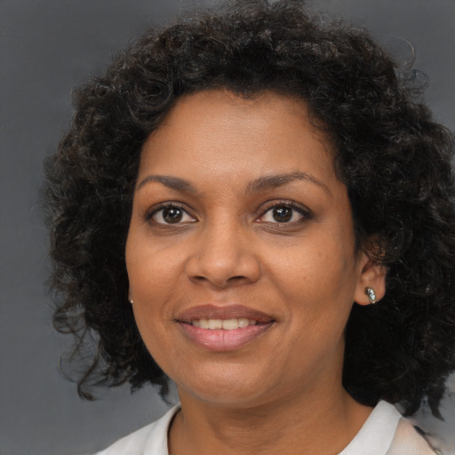 Joyful black adult female with medium  brown hair and brown eyes
