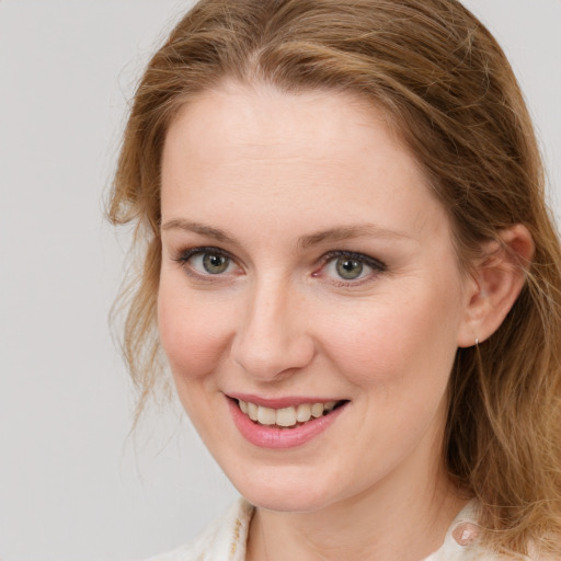 Joyful white young-adult female with long  brown hair and blue eyes