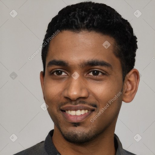 Joyful black young-adult male with short  black hair and brown eyes