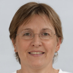 Joyful white adult female with medium  brown hair and grey eyes