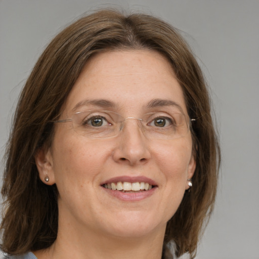 Joyful white adult female with medium  brown hair and grey eyes