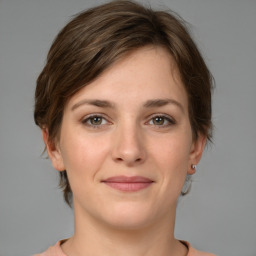 Joyful white young-adult female with medium  brown hair and grey eyes