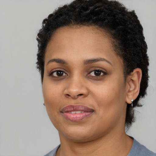 Joyful black young-adult female with short  black hair and brown eyes