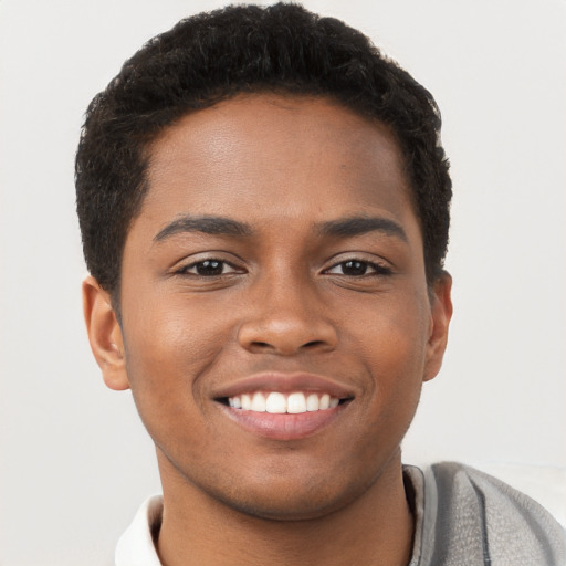 Joyful black young-adult male with short  brown hair and brown eyes